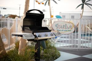 un barbecue posto accanto a una recinzione di The StarLux a Wildwood