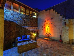 a stone building with a couch and a fireplace at Adanos Konuk Evi in Avanos