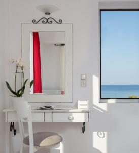 - un bureau blanc avec un miroir et une chaise blanche dans l'établissement Iris Beach Hotel, à Monemvasia