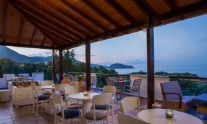 d'un restaurant avec des tables et des chaises et une vue sur les montagnes. dans l'établissement Iris Beach Hotel, à Monemvasia