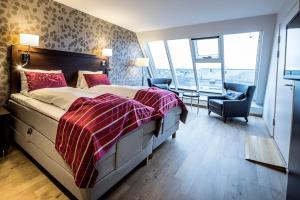 a bedroom with a large bed and a chair and window at Thon Partner Hotel Victoria Hamar in Hamar