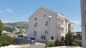 un immeuble d'appartements blanc avec une colline en arrière-plan dans l'établissement Sweet Dream 2, à Dubrovnik