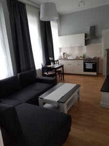 sala de estar con sofá, mesa y cocina en Pension Fischerjung, en Rostock