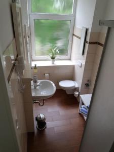 baño con ventana, lavabo y aseo en Pension Fischerjung, en Rostock