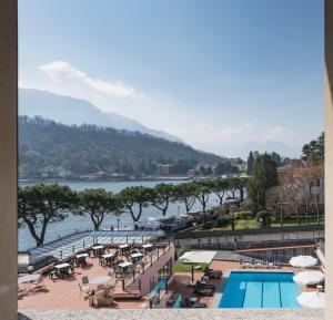 ein Hotel mit Pool und Blick auf das Wasser in der Unterkunft Hotel Lenno in Lenno