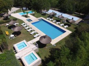 uma vista superior para uma piscina com cadeiras e guarda-sóis em Aldea de los Pajaros em Villa General Belgrano