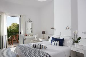 - une chambre blanche avec un lit et un balcon dans l'établissement Iris Beach Hotel, à Monemvasia