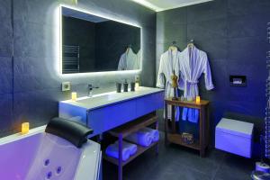 uma casa de banho azul com uma banheira e um lavatório em Suites Residences Spa em Colmar