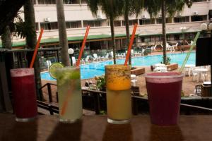 a group of drinks sitting on a table near a pool at Hotel El Libertador in Puerto Iguazú