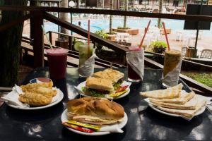 a table with plates of sandwiches and chips and drinks at Hotel El Libertador in Puerto Iguazú