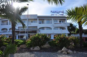 un hôtel avec des palmiers devant lui dans l'établissement Aparthotel Puerto Mar, à Peñíscola