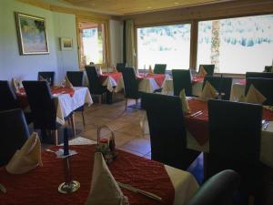 - un restaurant avec des tables et des chaises dans une salle dans l'établissement Hotel Pizzeria Selva, à Zernez