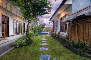 un jardín con rocas en el césped entre dos edificios en Bali Full Moon Guest House, en Canggu