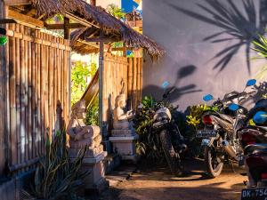 una casa con estatuas y una motocicleta estacionada al lado de un edificio en Bali Full Moon Guest House, en Canggu