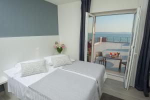 una camera bianca con letto e balcone di Seaside Luxury Suites a Podstrana