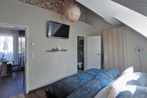 - une chambre avec un lit et une télévision murale dans l'établissement Frankfurt Bed & Breakfast, à Francfort-sur-le-Main