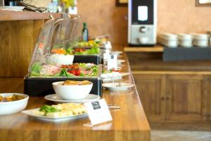 een buffet met salades en kommen eten bij Hotel Biathlon Sport & Spa in Szklarska Poręba