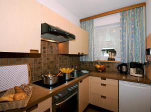 a kitchen with a sink and a counter with bread at Ferienwohnungen Rahm in Mayrhofen