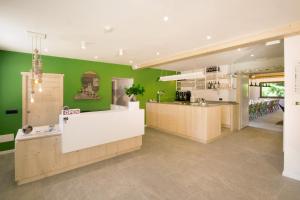 a restaurant with green walls and a white counter at Ostello Alpino in Bormio