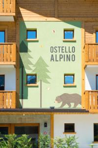 a sign on the side of a building with a bear on it at Ostello Alpino in Bormio