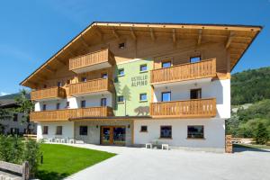 a large building with wooden balconies on it at Ostello Alpino in Bormio