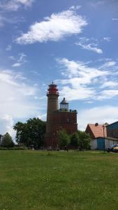 un faro sentado en la parte superior de un exuberante campo verde en Urlaub unter Reet, en Bergen auf Rügen