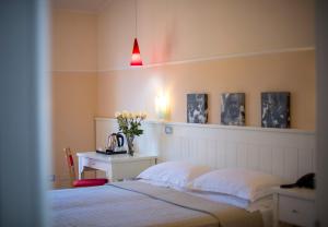 a bedroom with a bed and a table with a vase of flowers at Marin Hotel in Pula