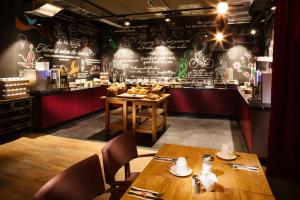 a restaurant with two wooden tables and a bar at pentahotel Paris Charles de Gaulle in Roissy-en-France