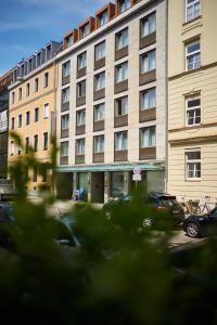 un gran edificio con coches estacionados frente a él en Hotel Concorde, en Múnich