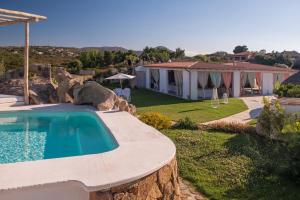 uma villa com uma piscina e uma casa em Hotel Ollastu em Costa Corallina