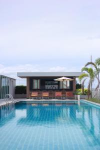 una grande piscina con sedie e ombrellone di The Whisper Hotel a Centro di Pattaya