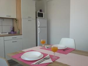 een keuken met een tafel met 2 glazen sinaasappelsap bij Studio apartman Toplica in Daruvar