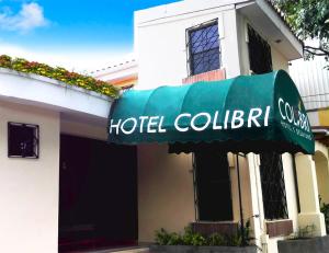 een collectief hotelbord aan de zijkant van een gebouw bij Hotel Colibri in Managua