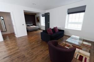 un soggiorno con 2 divani e un tavolo in vetro di Destiny Scotland -The Malt House Apartments a Edimburgo