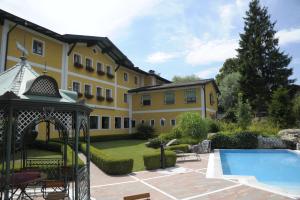 uma casa grande com uma piscina e um gazebo em Hotel Gasthof Kamml em Wals