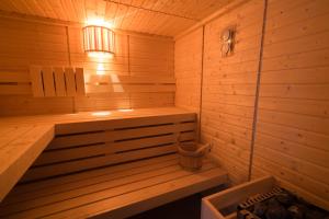 a wooden sauna with a bench and a light at La Tillaie SPA et Sauna in Pont-lʼAbbé-dʼArnoult