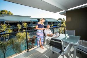 kobieta stojąca na balkonie z mężczyzną w obiekcie Ramada by Wyndham Hervey Bay w mieście Hervey Bay