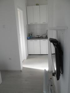 een keuken met witte kasten en een telefoon in een kamer bij Apartment Trebinje in Trebinje