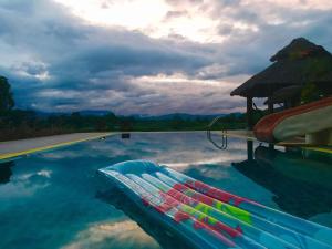 - une piscine d'eau bleue avec un parasol dans l'établissement KuadKhonThoe Pai Cottage, à Pai