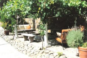 un jardín con dos bancos, árboles y plantas en Spanish Villa Inn, en St. Helena