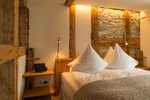 a bedroom with a bed with white sheets and a window at Boutique Hotel The River House in Andermatt