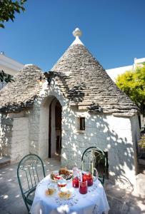 uma mesa em frente a um edifício com comida em Trullo Giardino Fiorito em Alberobello