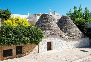 um edifício de pedra com um pássaro sentado em cima dele em Trullo Giardino Fiorito em Alberobello