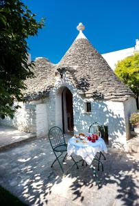 uma mesa e cadeiras em frente a um edifício em Trullo Giardino Fiorito em Alberobello