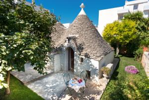 uma pequena casa com uma mesa no quintal em Trullo Giardino Fiorito em Alberobello