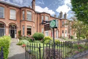 um edifício de tijolos com um sinal em frente em St. Aiden's Guesthouse em Rathgar