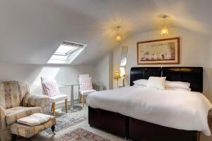 um quarto com uma cama grande e uma cadeira em St. Aiden's Guesthouse em Rathgar