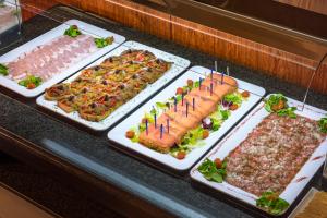 um buffet com vários tipos diferentes de alimentos em bandejas em 4R Casablanca Playa em Salou