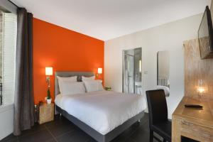 um quarto com uma cama com uma parede laranja em Hotel Douglas em Puteaux