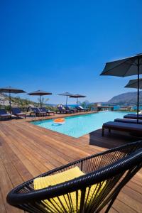 una piscina con sedie e ombrelloni su una terrazza di Seametry Apartments a Souda (Suda)